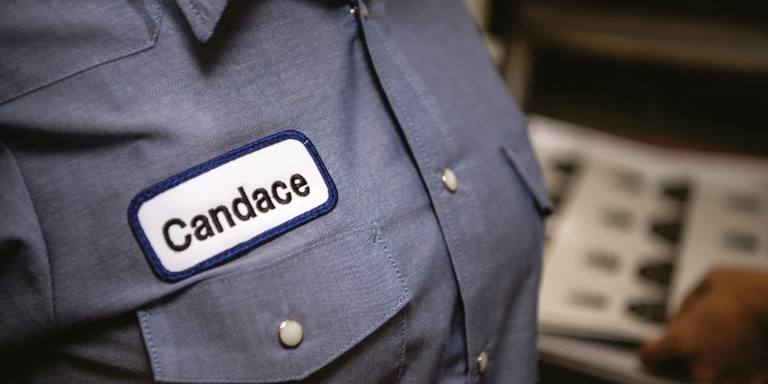 a woman's work shirt featuring a custom name badge