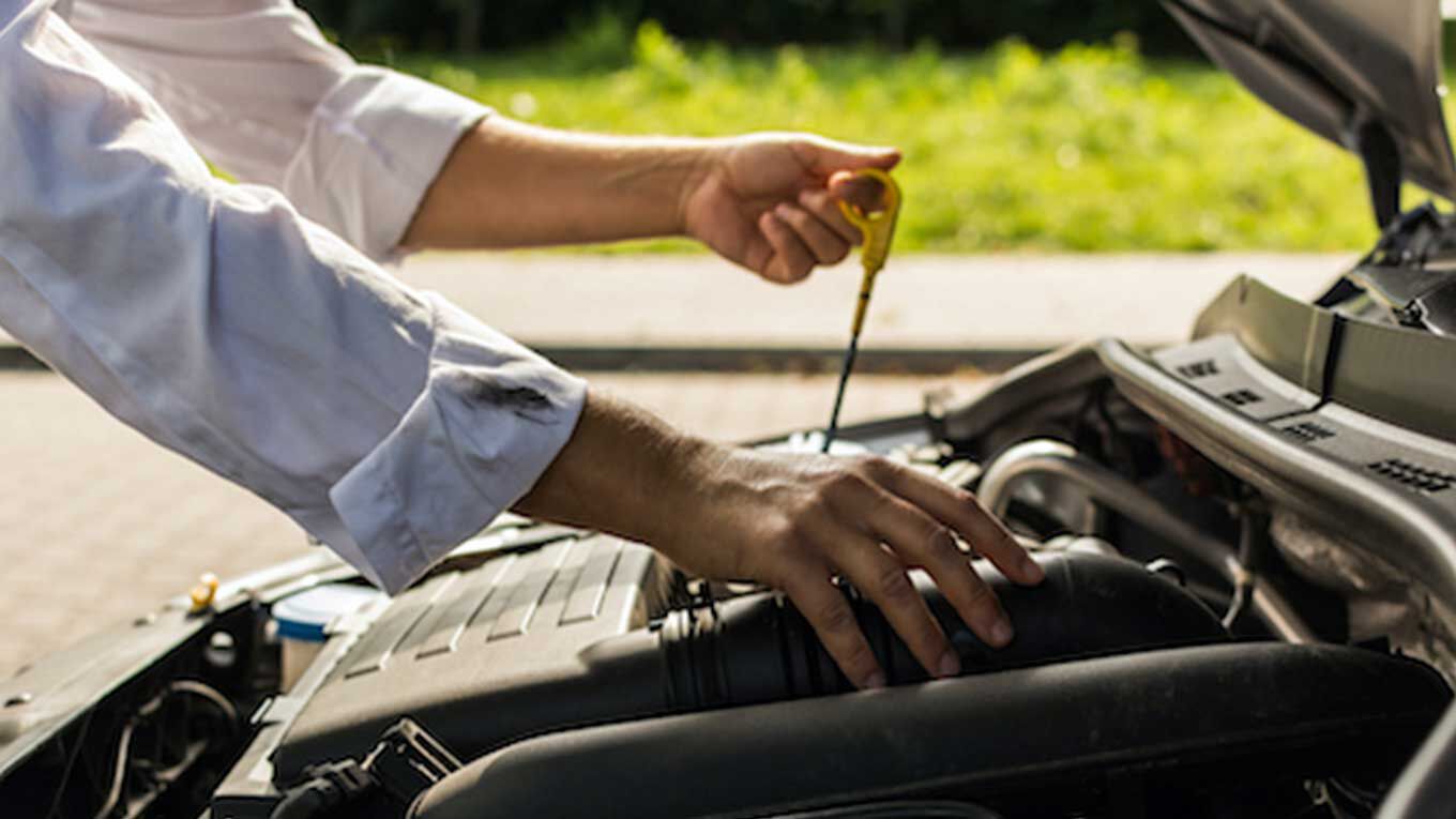 man checking oil in car man checking oil in car